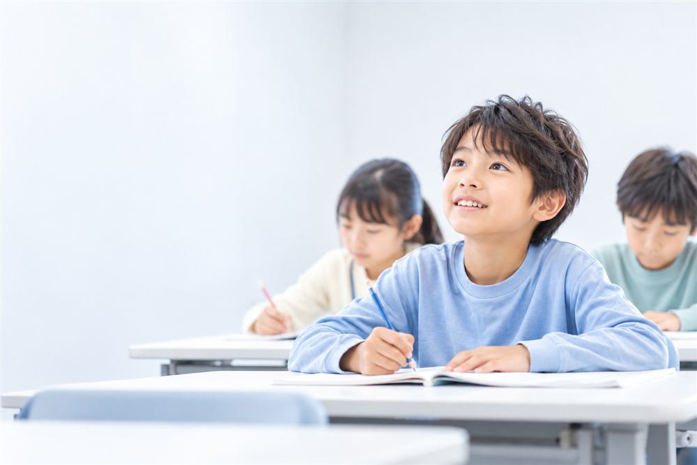 授業中に顔を上げて考える小学生（イメージ）
